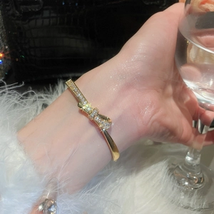 Close-up of 18k gold plated bow bracelet featuring shimmering pavé set cubic zirconia