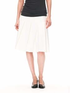 Minimalist white mid-length pleated skirt styled with black slim top on white background