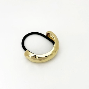 Detailed view of golden hammered texture hair tie with high-elasticity black band