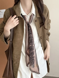 Gros plan du collier foulard en soie à motif cachemire rétro et style daim marron
