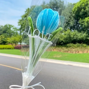 Close-up of a handmade blue tulip pipe cleaner flower in transparent LOVE gift wrap