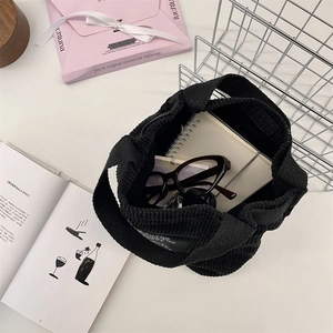 Vue intérieure du sac seau en velours côtelé noir montrant la capacité de rangement