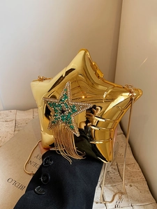 Close-up of golden star-shaped evening bag with crystal tassels and shooting star detail