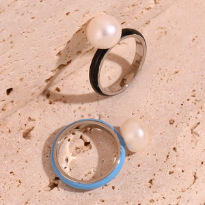 Detailed macro of enamel rings in black and sky blue with elegant white pearls