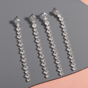 Detail of silver long tassel drop earrings with sparkling geometric crystal rhinestones