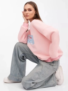 Seitenansicht des rosa Sweatshirts mit blauem Grafikdruck und lockerem Rundhals-Schnitt