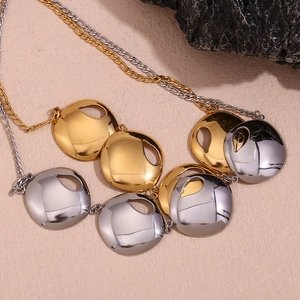 Detailed shot of two-tone gold and silver cutout disc pendants on a fine chain necklace
