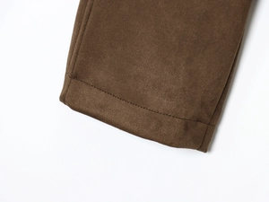 Close-up of the dark brown suede fabric texture and stitching on the jacket cuff