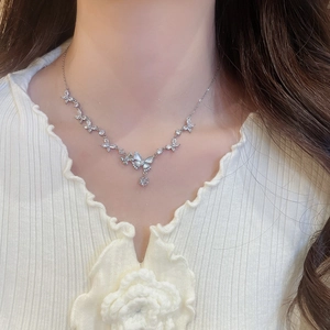 Detailed close-up of a silver butterfly pendant necklace with sparkling zircon stones
