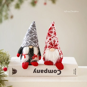 Set of two Christmas gnomes with knit snowflake hats and white beards on a book