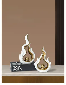 Detail of minimalist ceramic flame sculptures with gold interior and metallic sphere