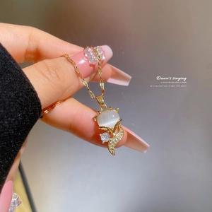 Detailed view of fox pendant necklace featuring cat eye stone and pavé crystal accents