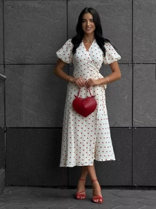 Detail of white cotton dress featuring red heart patterns and stylish waist tie