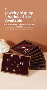 Detailed layered walnut wood jewelry trays with plush red velvet lining for display