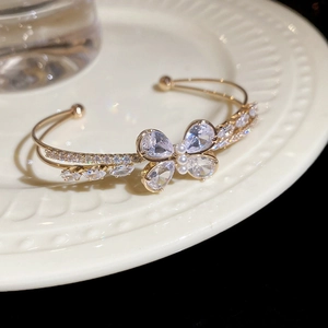 Detail of gold butterfly bracelet with pear-shaped zircons and tiny white pearls