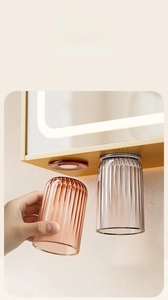 Detail of magnetic inverted toothbrush holder with two amber and gray ripple texture cups
