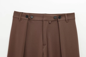 Detailed close-up of dark brown suit trousers featuring a waist button and belt loops