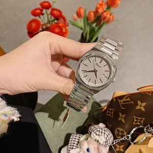 Close-up of a silver metal watch with a minimalist square dial and date display window