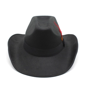 Detail of a black felt cowboy hat featuring a vibrant orange and red feather ornament