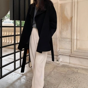 Women's black wool blend lapel coat with waist belt and wide leg pants in street style