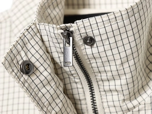 Macro detail of high-quality metal zipper and snap button on checkered nylon jacket