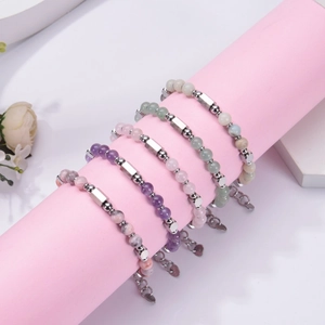 Detail of five colorful natural stone bead bracelets with adjustable metal chains on a prop