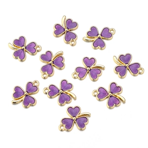 Detail of ten purple clover alloy pendants with gold plating for DIY jewelry making