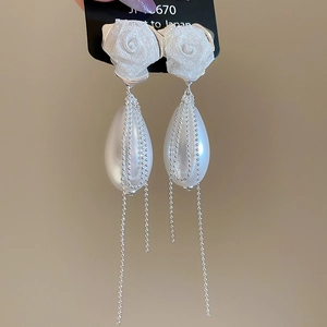Detail of rose lace earrings featuring water drop pearls and delicate silver tassels