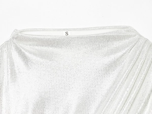 Gros plan sur la texture en mesh blanc et l'étiquette taille S de la robe à strass
