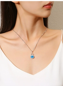 Detail of S925 silver necklace featuring a blue oval gemstone with heart-shaped link