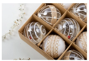 Detailed view of clear Christmas ornaments with berries and pearls in a kraft paper box
