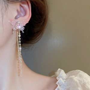 Pink butterfly tassel drop earrings with sparkling rhinestones and pearls on a model
