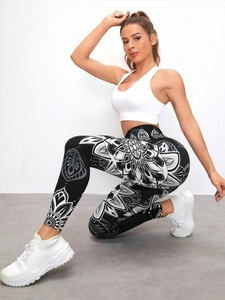 Detail of high waisted yoga leggings featuring white mandala print on dark stretchy fabric