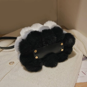Close-up of plush crossbody bag featuring faux fur texture and gold metal studs on base