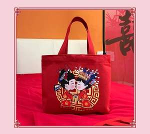 Detail view of red canvas wedding gift bag with cartoon bride and groom illustration