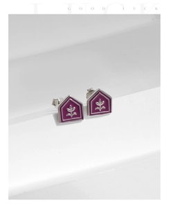 Detail of s925 silver house-shaped earrings with purple enamel and leaf pattern