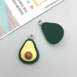 Detailed macro view showing cute cartoon avocado resin pendant with smiling face and ring