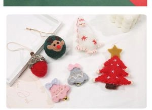 Handmade wool felt Christmas tree ornaments including reindeer and Santa on white fabric