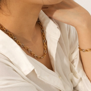 Two-tone gold and silver stainless steel chain necklace and bracelet set on a model