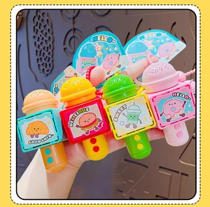 Detail of four colorful cartoon microphone keychains with food graphics held in hand