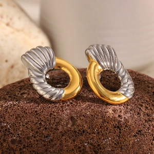 Macro detail of two-tone oval earrings with twisted shell texture and 18K gold finish