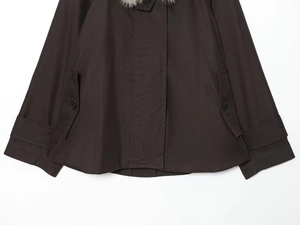 Detail view of the deep brown waterproof parka with large pockets and decorative cuffs