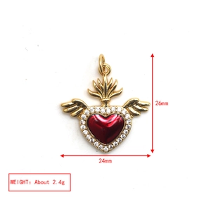 Macro shot of 24mm x 26mm golden winged heart pendant with red stone and clear crystals