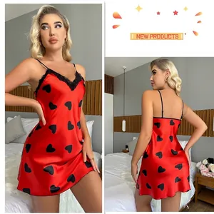 Nuisette rouge en satin de soie à motifs cœurs avec dentelle noire sur fond de chambre