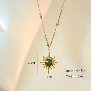 Detail view of 14K gold star pendant with green stone, showing size 2.1cm by 1.7cm