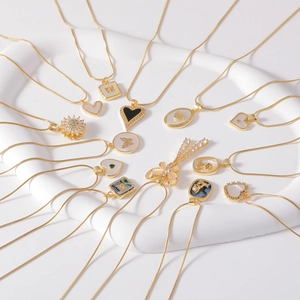 Detail of assorted golden necklaces with heart and flower pendants on white display tray