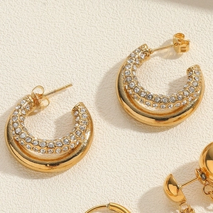 Detail of 18K gold-plated C-shaped earrings with double rows of sparkling cubic zirconia
