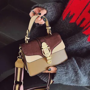 Detail of vintage patchwork handbag with matte flap, gold buckle and striped strap