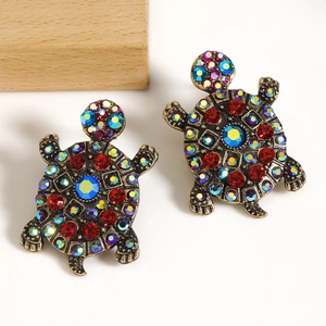 Close-up of turtle earrings with colorful crystals on vintage gold alloy finish