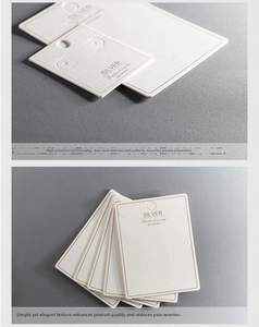 Macro detail of white textured jewelry display cards with gold foil handmade branding